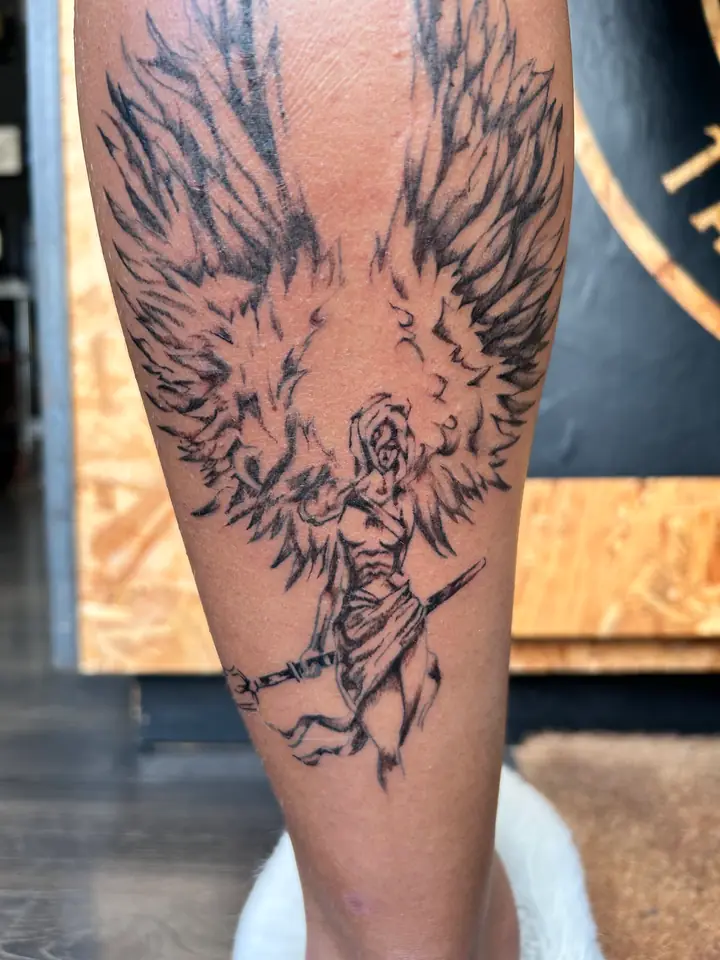 Winged engraving-style tattoo on a calf by Lady Jane