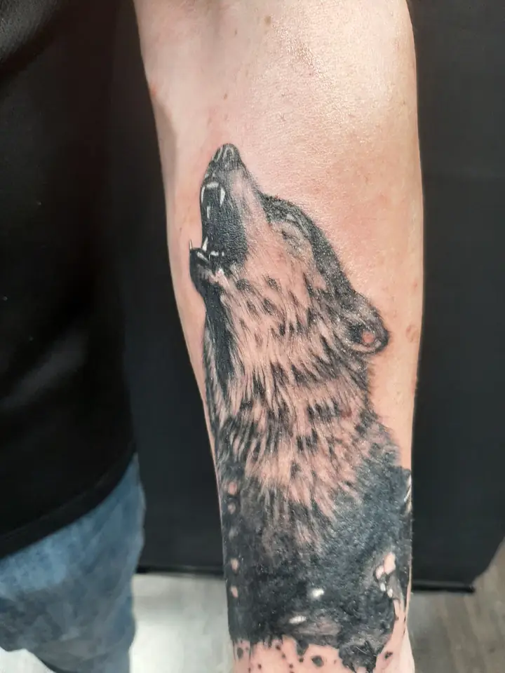 Howling wolf blackwork realism forearm tattoo